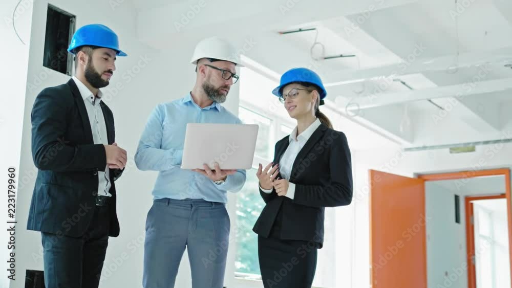 Engineers in hardhats have conversation in a factory Engineers in hardhats have conversation in a factory