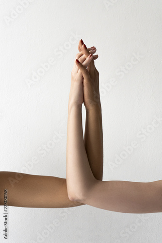 Women of different skin color holding hands