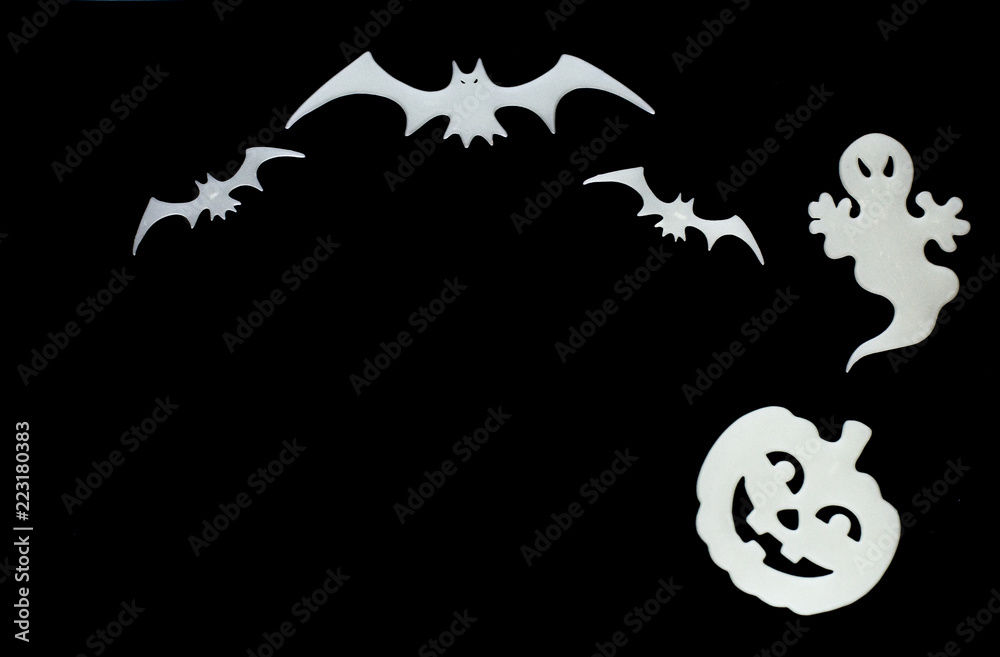 Close up white symbols of Halloween. Bats, pumpkin, ghost isolated on black background.