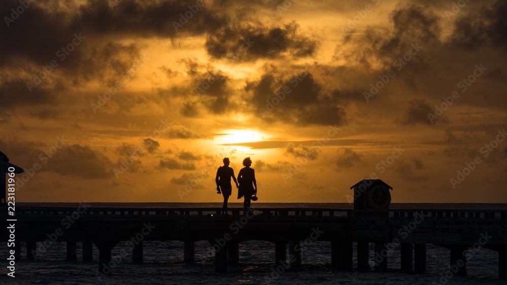 Couple on sunset background in Maldives.