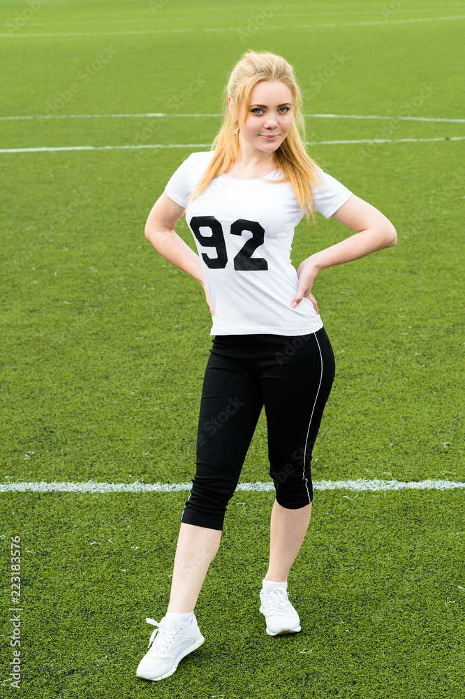 sports woman standing full length on green grass football field