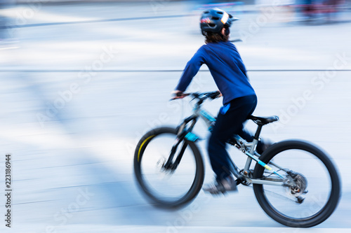 bicycle riding kid in the city in motion blur