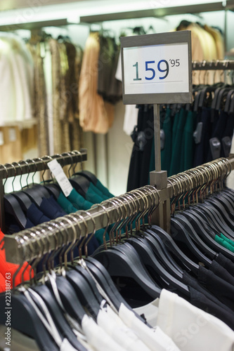 Fashionable men's and women's clothing on wooden hangers in a modern clothing store. 