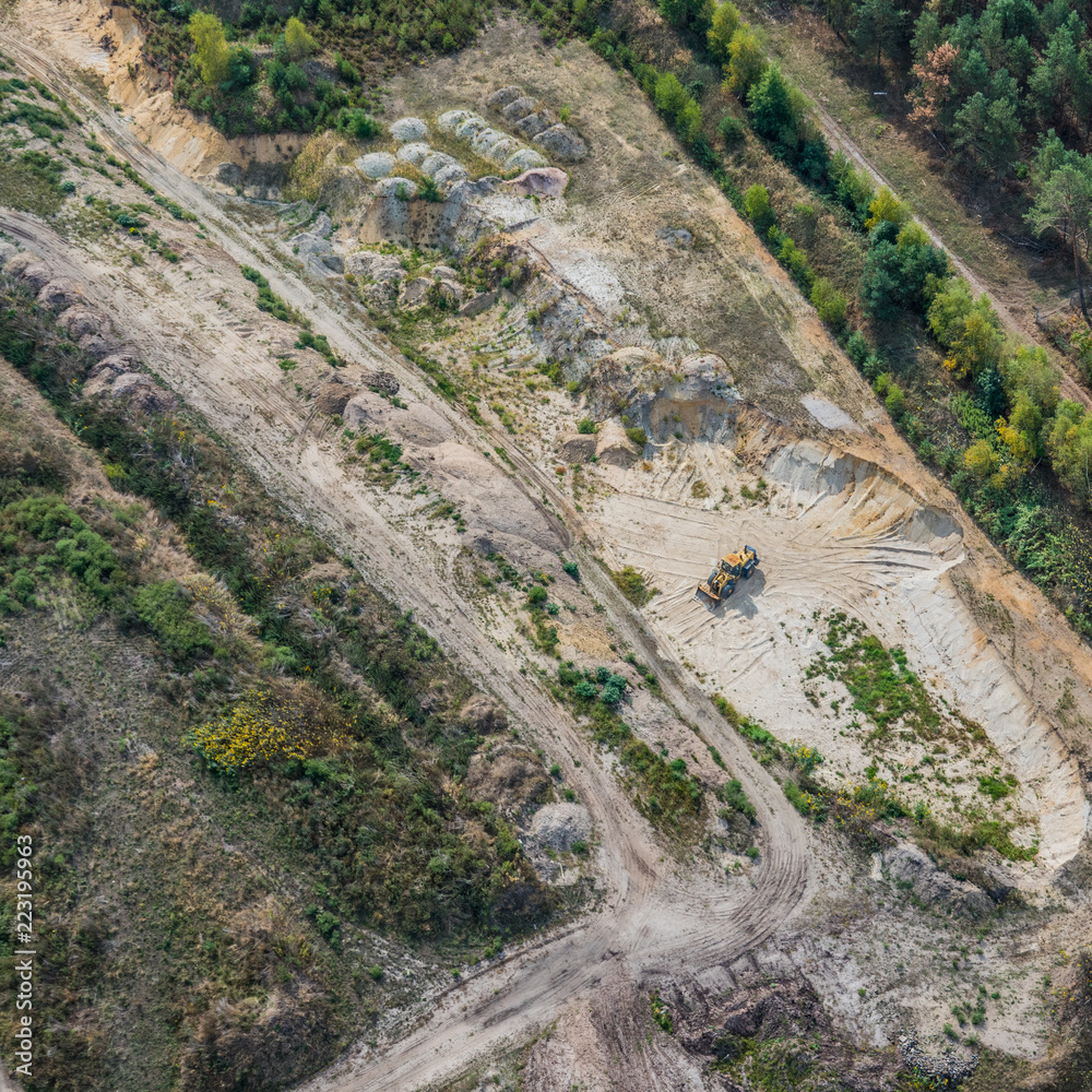 Vertical aerial view of a sand quarry in the heath with a wheel loader, flight with a gyrocopter Vertical aerial view of a sand quarry in the heath with a wheel loader, flight with a gyrocopter