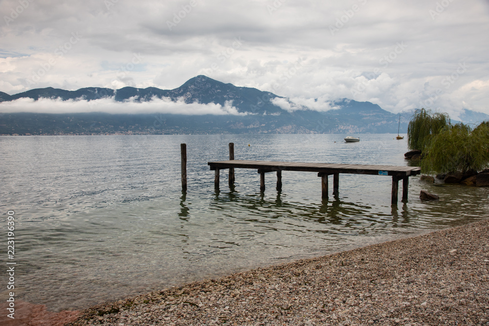 Landscape of lake Garda with a wooden pier