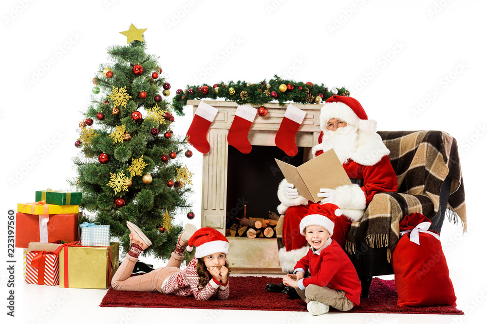 kids and santa looking at camera while relaxing in front of fireplace isolated on white kids and santa looking at camera while relaxing in front of fireplace isolated on white