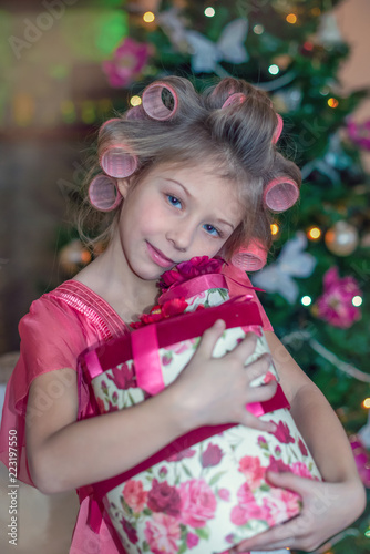 Happy little cute girl with christmas gift box close to christmas tree/ Christmas Eve/ Merry Christmas/Happy Holidays