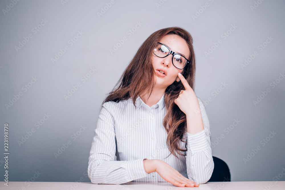 Teacher or business woman with glasses sitting at table Teacher or business woman with glasses sitting at table