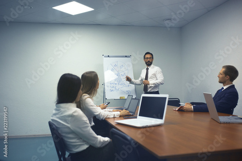 Successful businessman making presentation of new market strategies in office. Business concept.