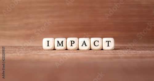 Word IMPACT made with wood building blocks