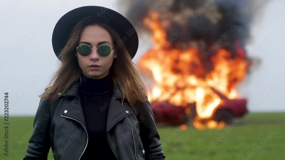 Stylish model against the background of an exploding car, girl and exploding car Stylish model against the background of an exploding car, girl and exploding car
