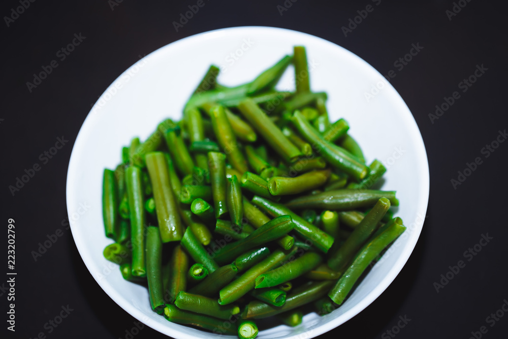 Cooked green beans on black background. Close up Cooked green beans on black background. Close up
