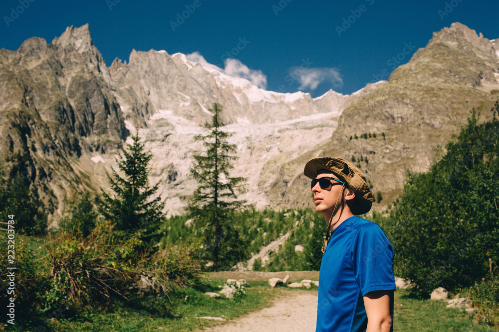 tourist wearing hat and sunglasses ,on european alps background tourist wearing hat and sunglasses ,on european alps background