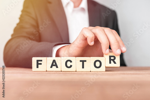 Man made word FACTOR with wood blocks
