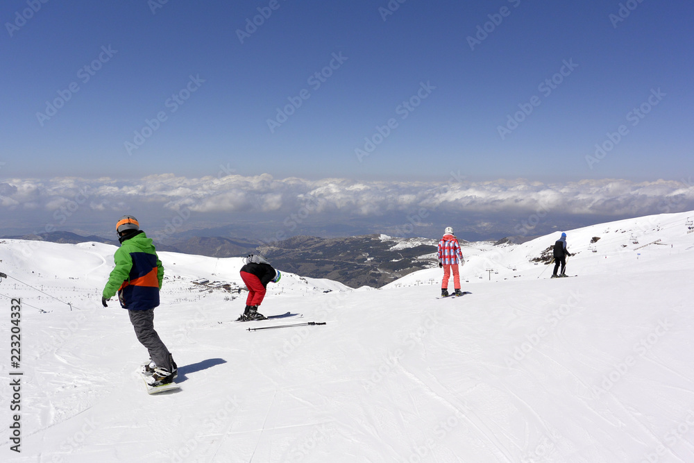 On the snow-capped peaks of  the mountain Sierra Nevada skiers and snowboarders