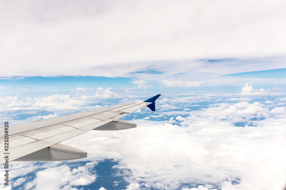 Fototapeta premium Looking through window aircraft during flight in wing with a blue sky