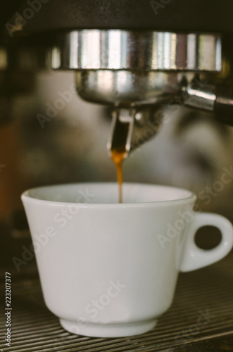 Coffee cup filling with coffee on a machine