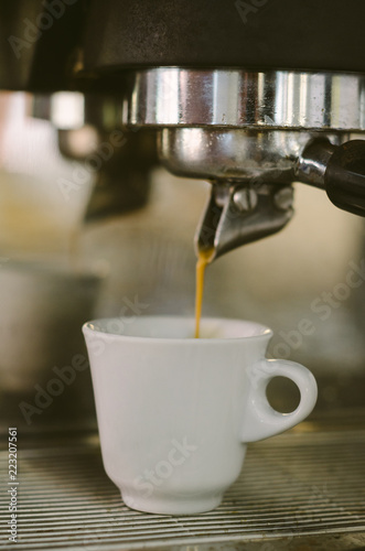 Coffee cup filling with coffee on a machine