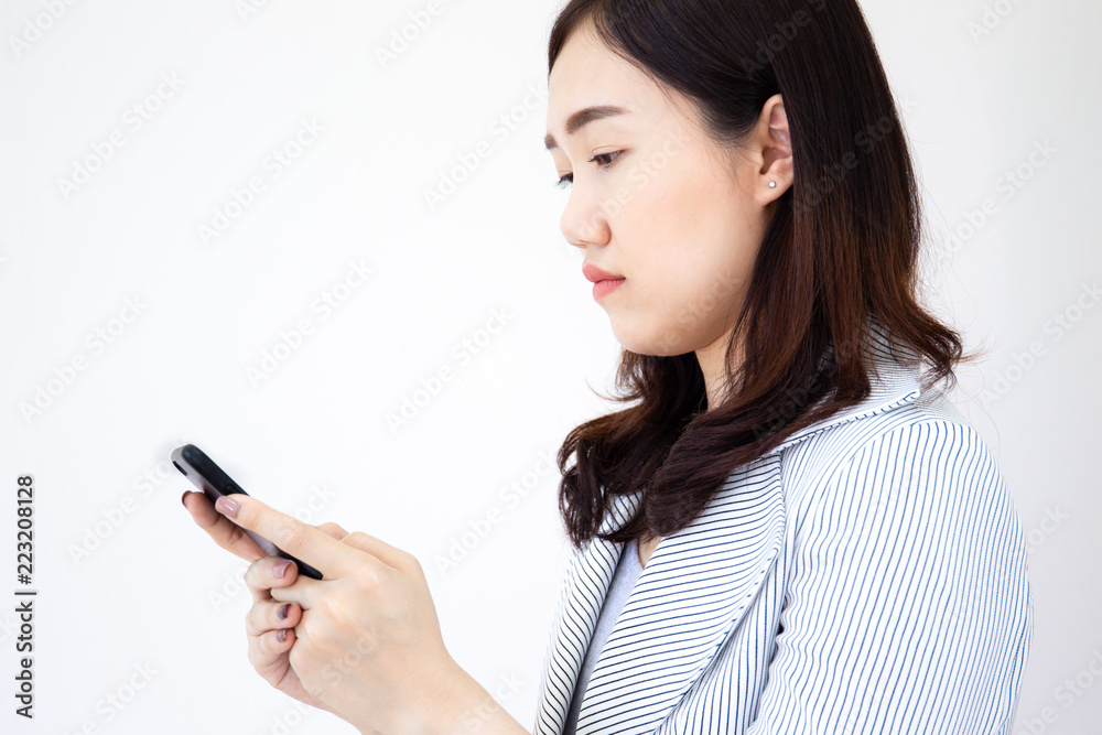 Portrait of smart and beautiful Asian lady in business suit checking an email on her smartphone Portrait of smart and beautiful Asian lady in business suit checking an email on her smartphone