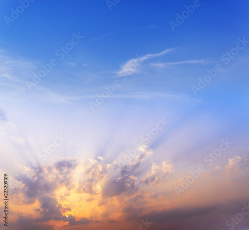 sunset / sun rise sky with rays of yellow and red light shining clouds and sky background and texture
