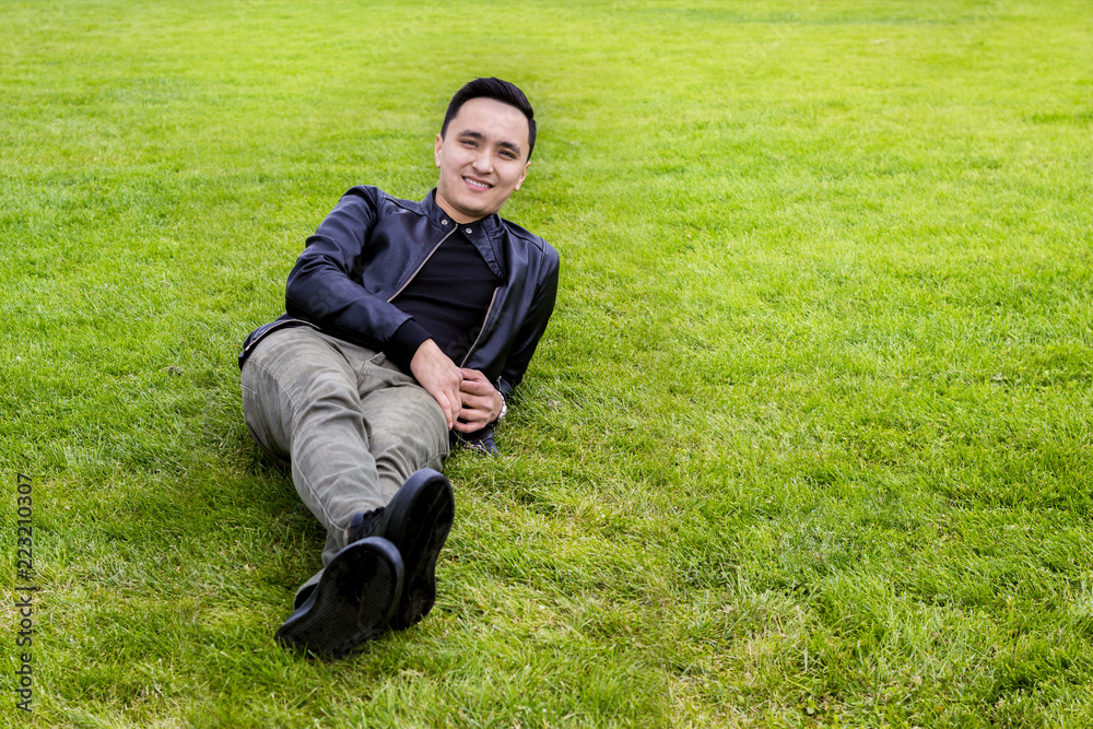 Asian yong man lying on the grass Asian yong man lying on the grass