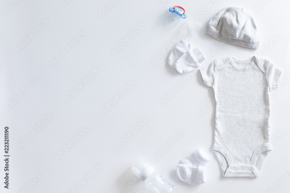 Its a boy or girl, baby background. Unisex neutral theme with baby shower or nursery concept with baby clothes on white background, flat lay and top view. Its a boy or girl, baby background. Unisex neutral theme with baby shower or nursery concept with baby clothes on white background, flat lay and top view.