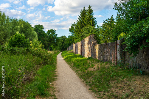 The trail along the old stone wall on one side and forest on the other. © Sergey Kohl