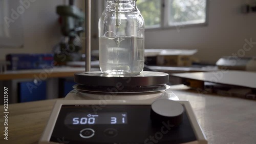 Solution stirring in laboratory beaker with magnetic stirrer, slow motion photo