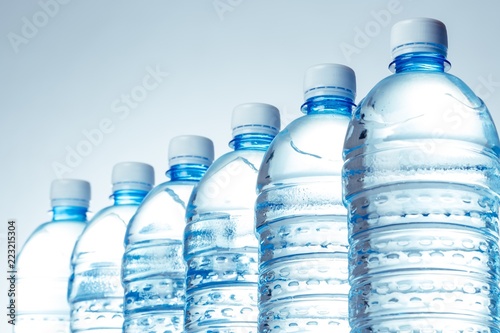 Six Water Bottles in a Row on the Blue Background