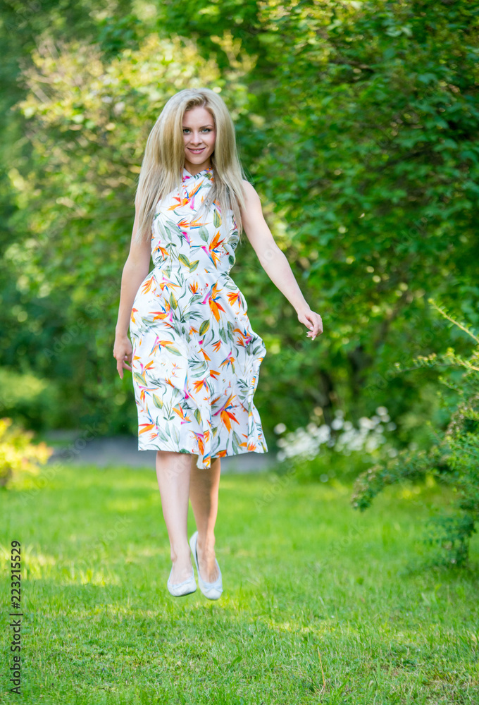 Beautiful young girl in a dress walking in the summer Park Beautiful young girl in a dress walking in the summer Park
