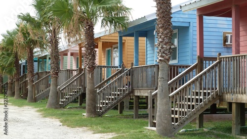 Row of small colorful wooden tiny beach houses and palm trees, Gulf of Mexico
