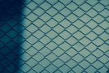 Creative abstract shadows of chain link fence wire mesh steel metal isolated on color background. Art design gate made. Prison barrier, secured property. Abstract concept graphic element