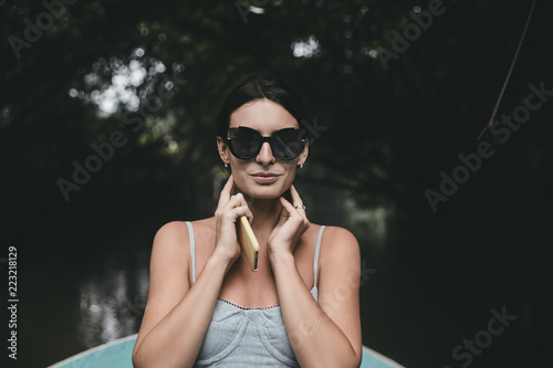 Beautiful brunette on the jungle river in the boat portrait