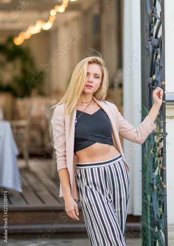 Beautiful young girl in a suit walking around the summer city