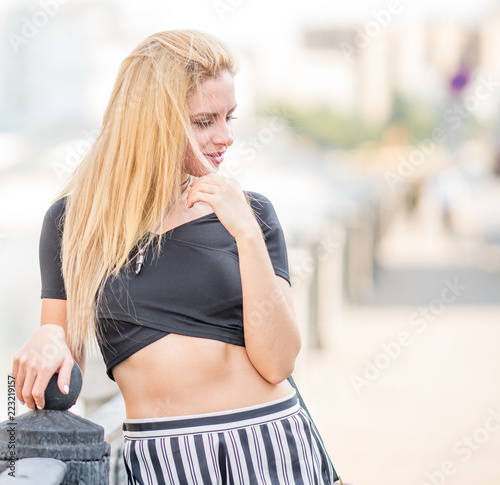 Beautiful young girl in a suit walking around the summer city