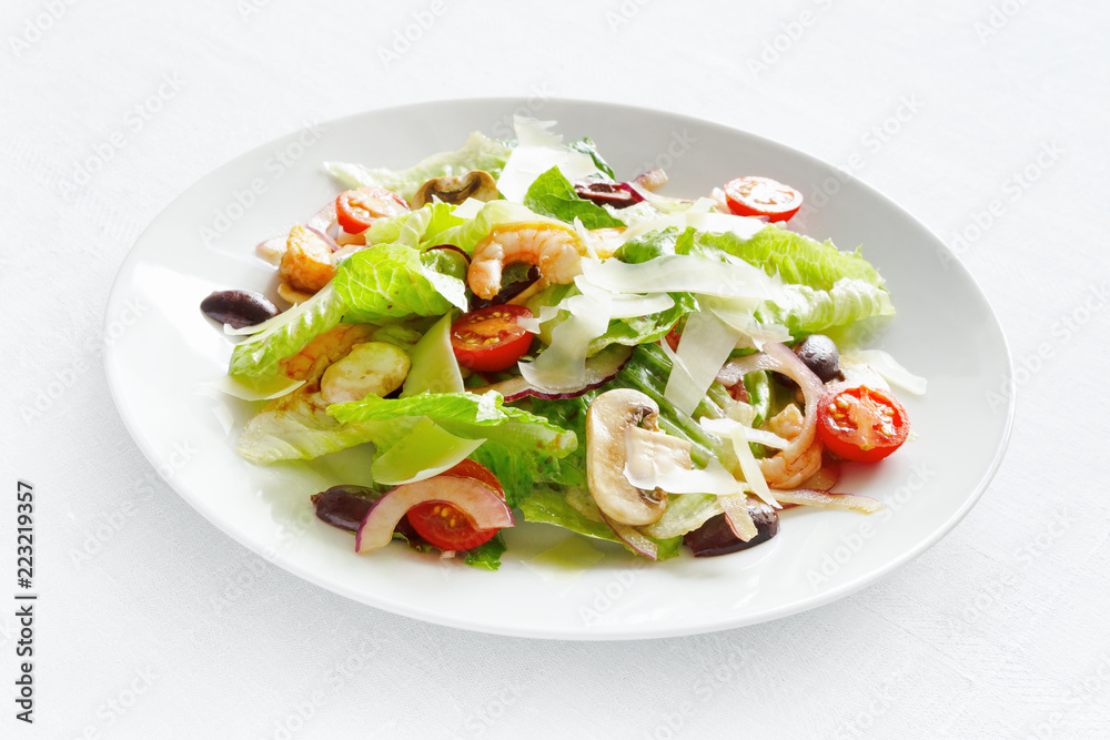 romaine salad with scampi, champingons, tomatoes, olives, and onion dressed with modena vinegar and olive oil and sprinkled with parmesan
