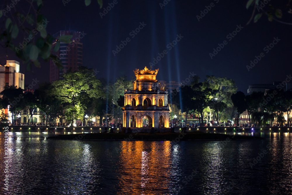 The heart of old Hanoi Hoan Kiem Lake at night illuminated by lights with a bright reflection in the water