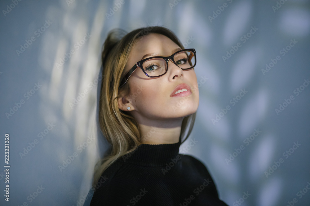 Lichtspiele im Gesicht einer blonden Studentin mit Brille Lichtspiele im Gesicht einer blonden Studentin mit Brille