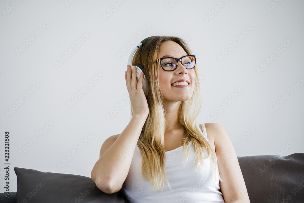 Junge Frau sitzt auf der Couch und hört Musik Junge Frau sitzt auf der Couch und hört Musik
