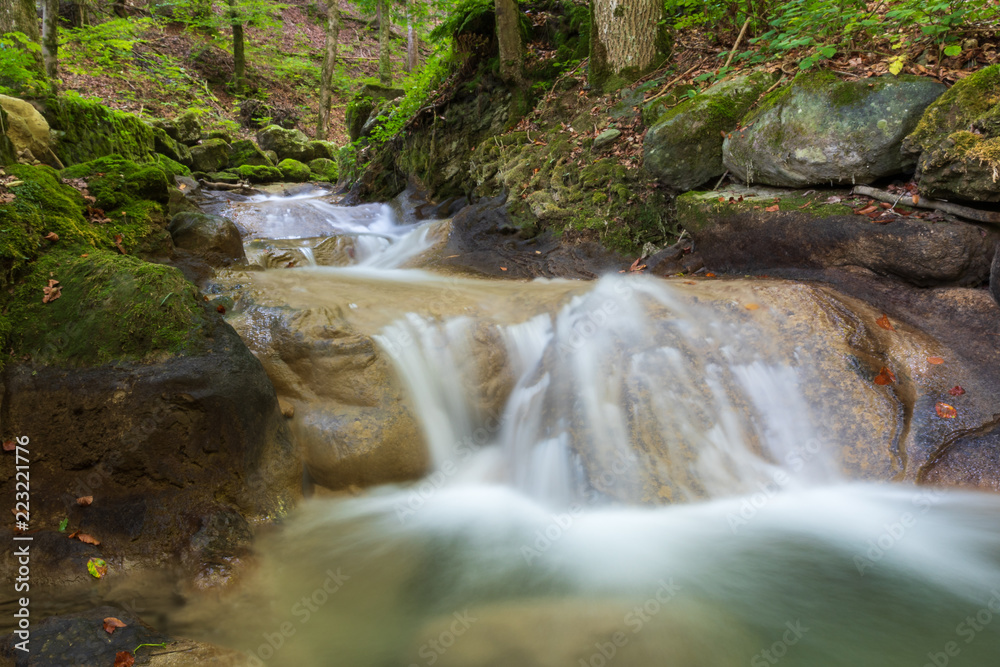Fototapeta premium Bach mit Wasserfall im Wald im Herbst