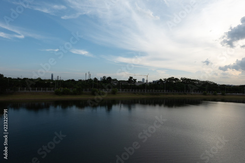 a beautiful lakescapse with blue sky city in the evenning with sunset and white cloud. © arwiyada
