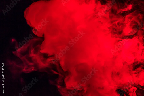 Colorful smoke on a black background of red and white colors. The concept of smoking. Beautiful textural background