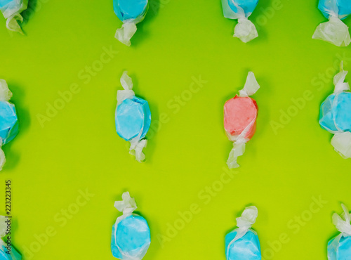 Blue and red taffy candy on bright green background, shows being different with food color.   photo