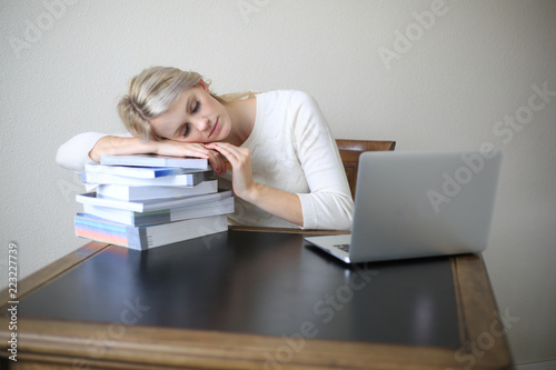 woman asleep on a pile of textbooks
