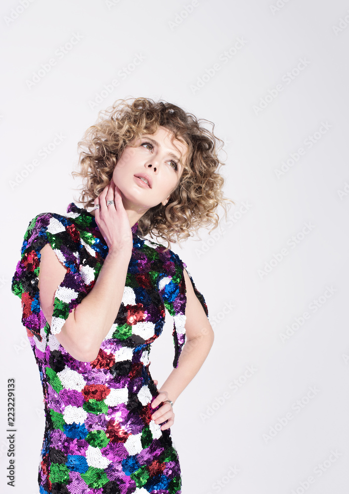 Young beautiful woman chooses something or thinks about something. Curly hair and bright dress Young beautiful woman chooses something or thinks about something. Curly hair and bright dress
