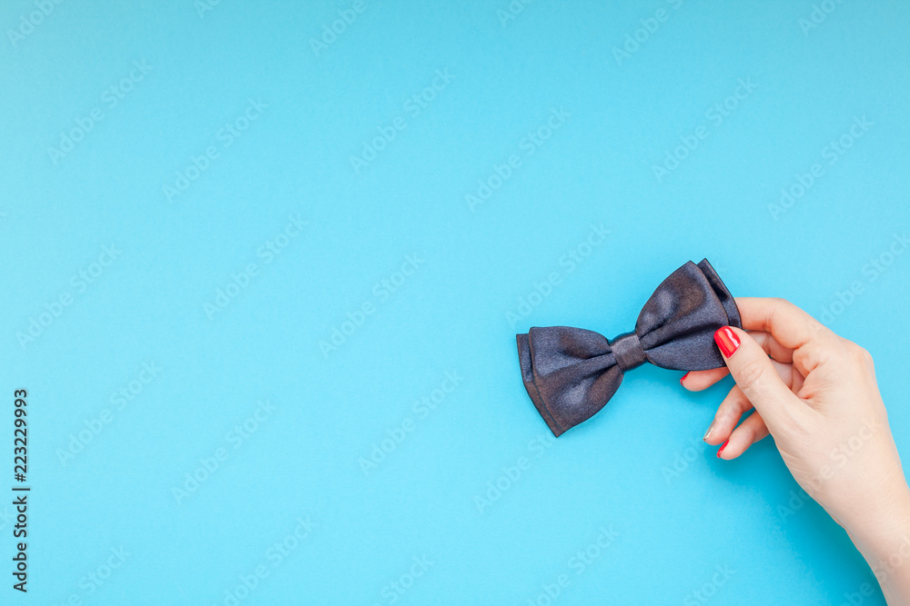 Black bow tie woman hand for men fathers concept - obrazy, fototapety, plakaty 