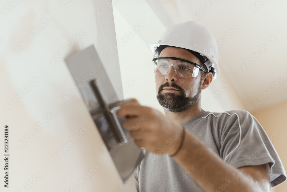 Ταπετσαρία Professional craftsman applying plaster with a trowel