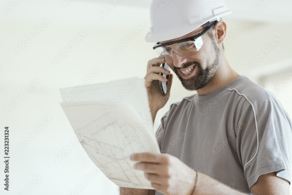 Fotografie Smiling architect having a phone call