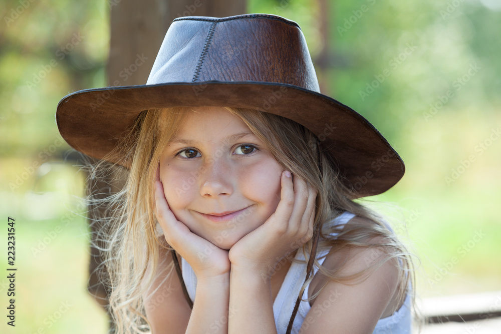 Charming girl in leather cowboy hat portrait, blond hair, brown eyes