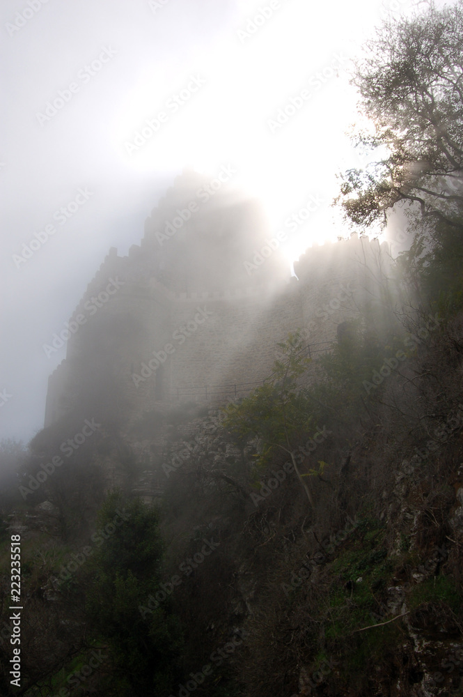 Balio castle on the mountain in the fog Erice Sicily Italy back lighting